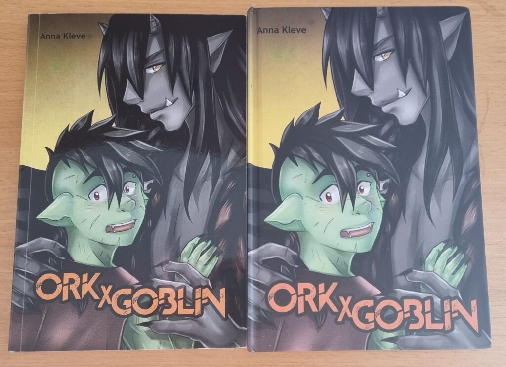 Auf diesem Bild sieht man zwei Ausgaben von Ork x Goblin des Littera Magia Verlags.Links das Softcover und Rechts das Hardcover