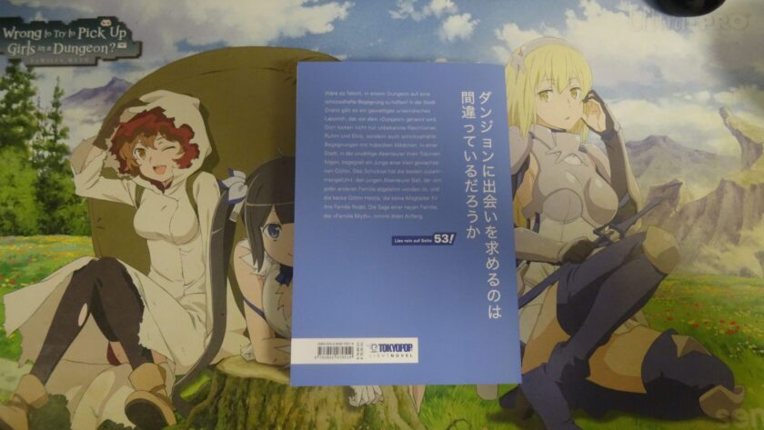 Das Bild zeigt die hellblaue Rückseite des Buches. Auf der Rückseite steht der japanische Titel und die Offizielle Beschreibung