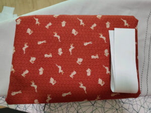 red fabric with a japanese pattern and many small off-white rabbits in different poses on it