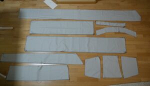 all the pattern-pieces cut out of fabric and laid out on the floor. The skirt pieces are mostly rectangles, the shirring panel is a trapezoid. there is also long wait-ties and all the pieces for the (wrong bodice)