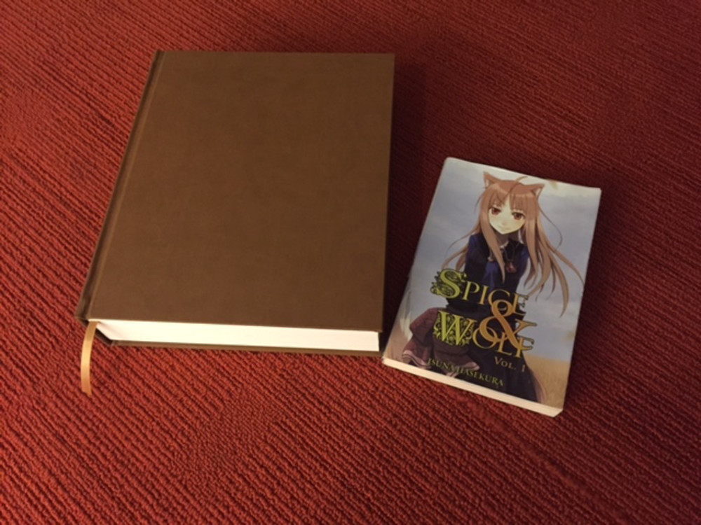Das Bild zeigt einen Größenvergleich zwischen der normalen Light Novel und der Collector Anniversary Edition. Die Anniversary Edition ist größer, breiter und wesentlich dicker.